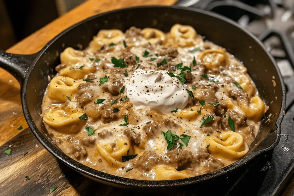Skillet filled with Beef Stroganoff Tortellini, featuring creamy sauce and tender beef.